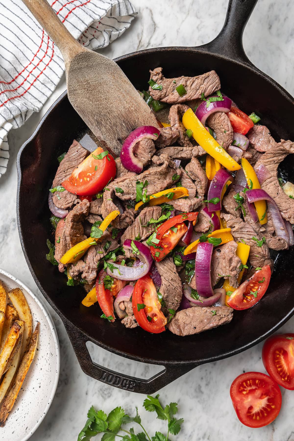 Overhead view of lomo saltado cooking in skillet